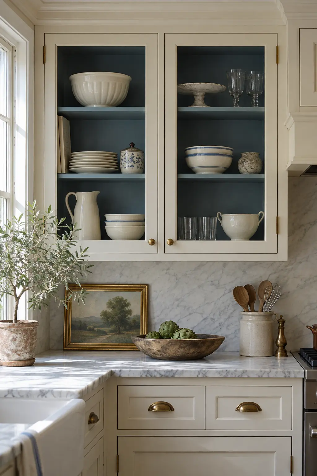 Glass-front kitchen cabinets with contrasting blue painted interiors and neatly arranged dishes