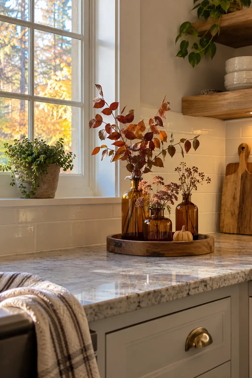 Kitchen side counter with three amber bud vases and individual autumn stems
