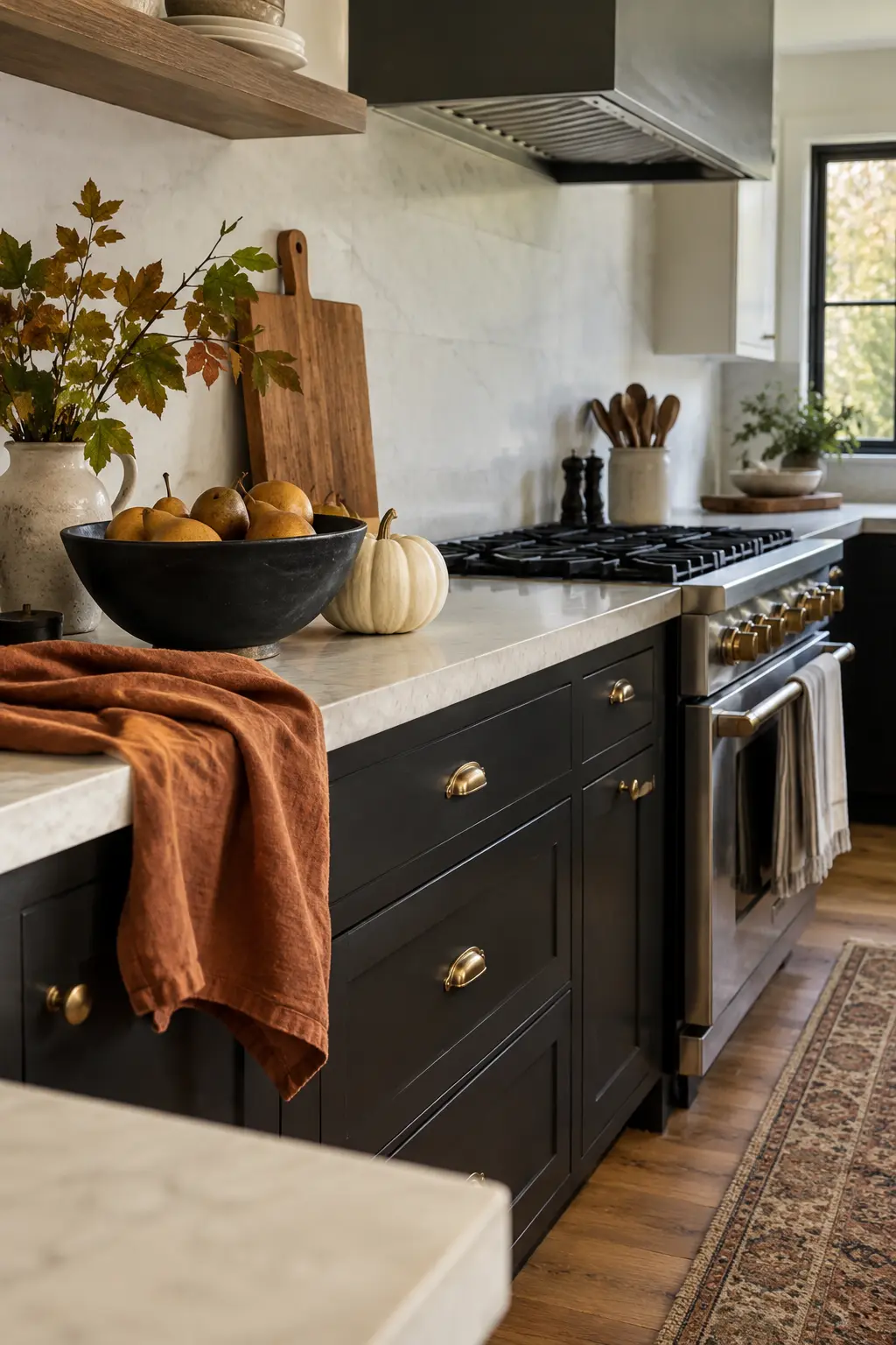 Modern black-and-white kitchen with dark branches, white pumpkins, and a wood tray