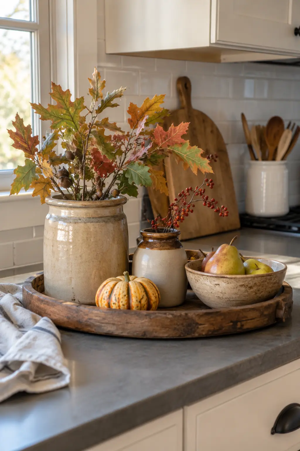Thrifted stoneware jar with autumn branches on a small kitchen tray