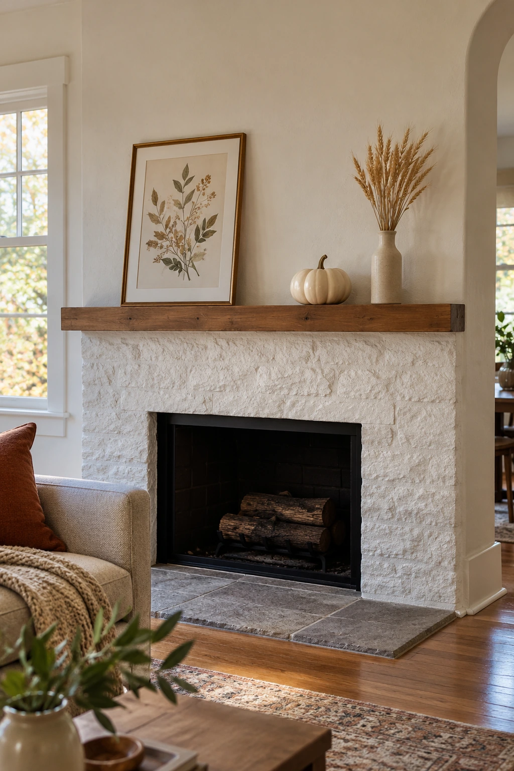 Shallow Thanksgiving mantel ledge with a vase, framed landscape, and small pumpkin